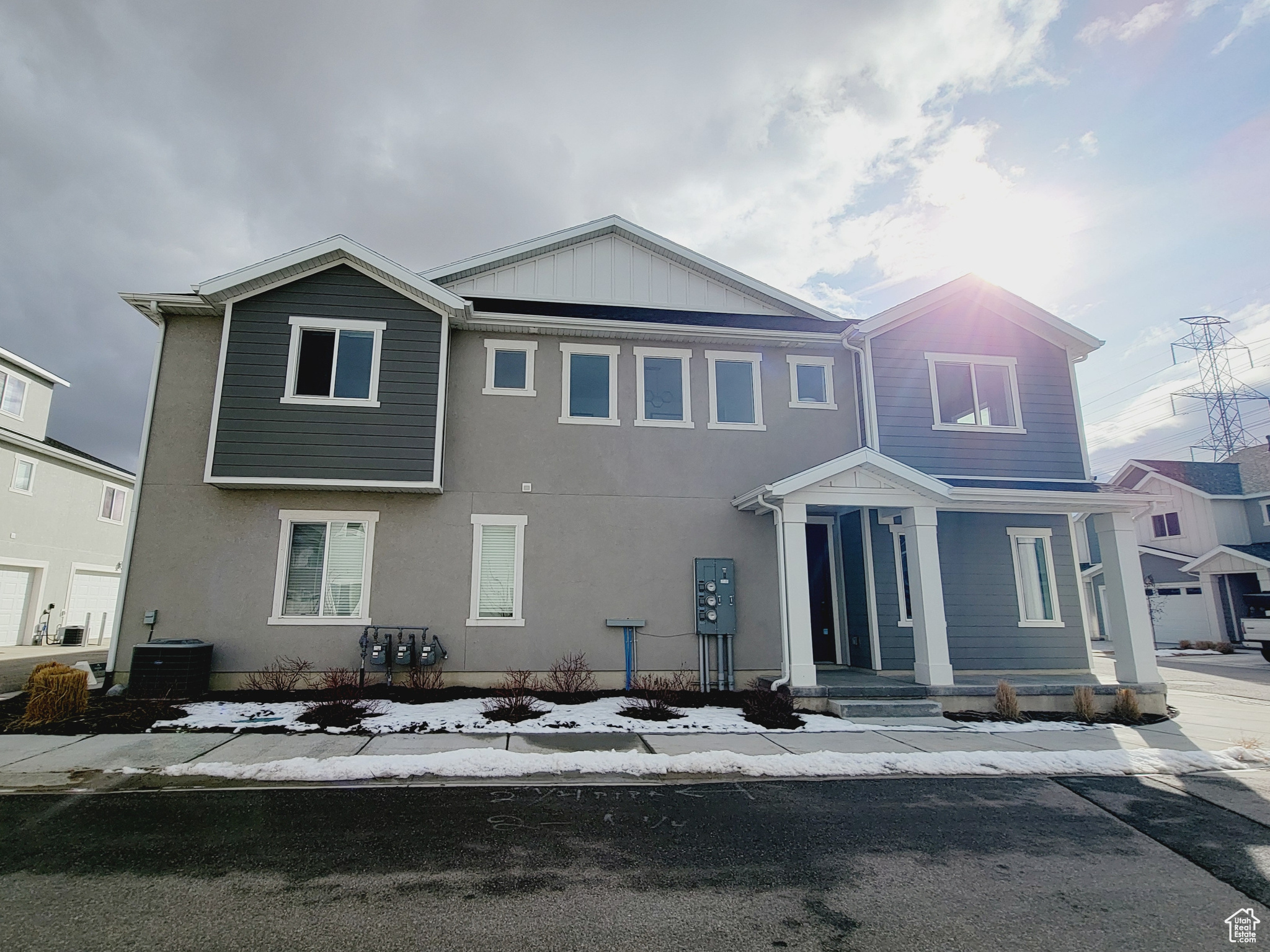 View of front of home with central air condition unit and a garage