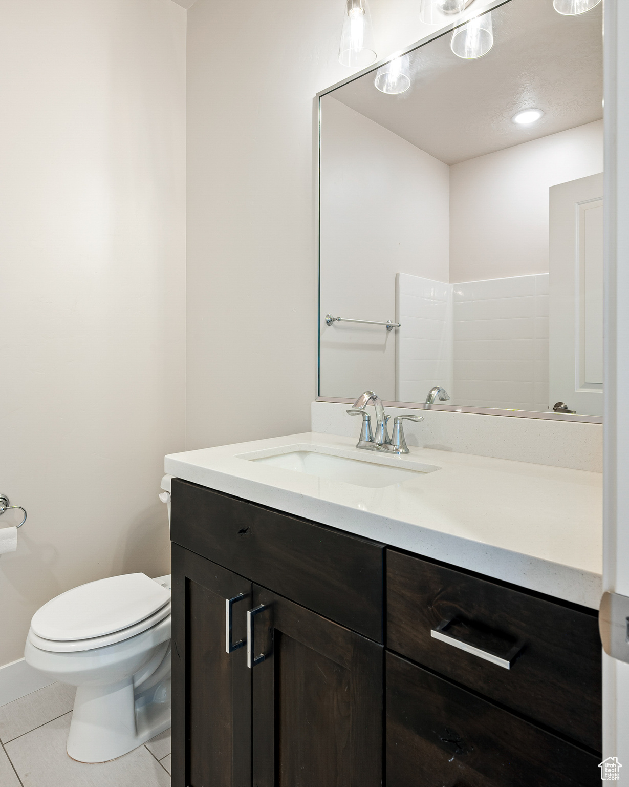 Bathroom with vanity, toilet, and tile patterned floors