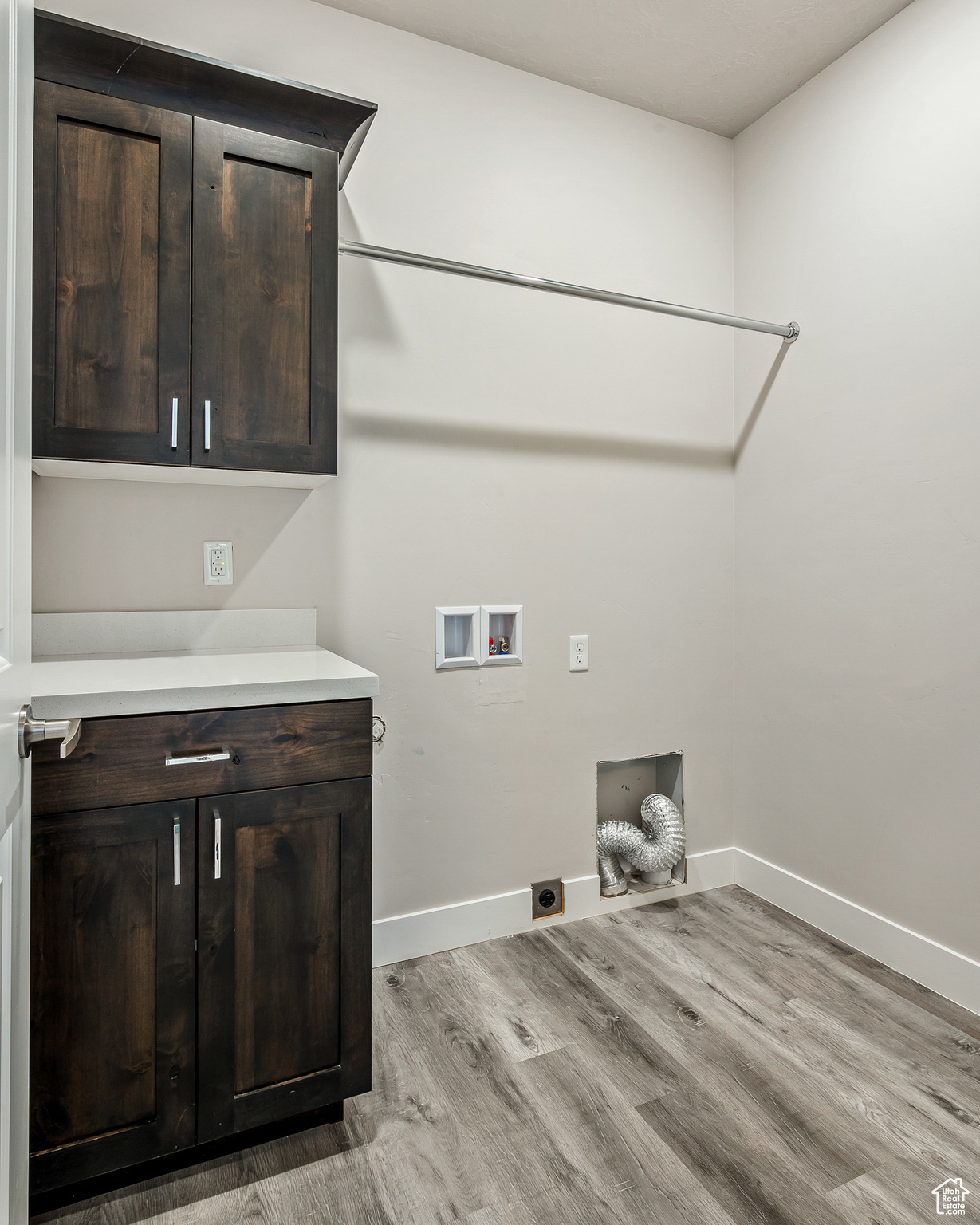 Laundry area with light hardwood / wood-style floors, washer hookup, cabinets, and hookup for an electric dryer