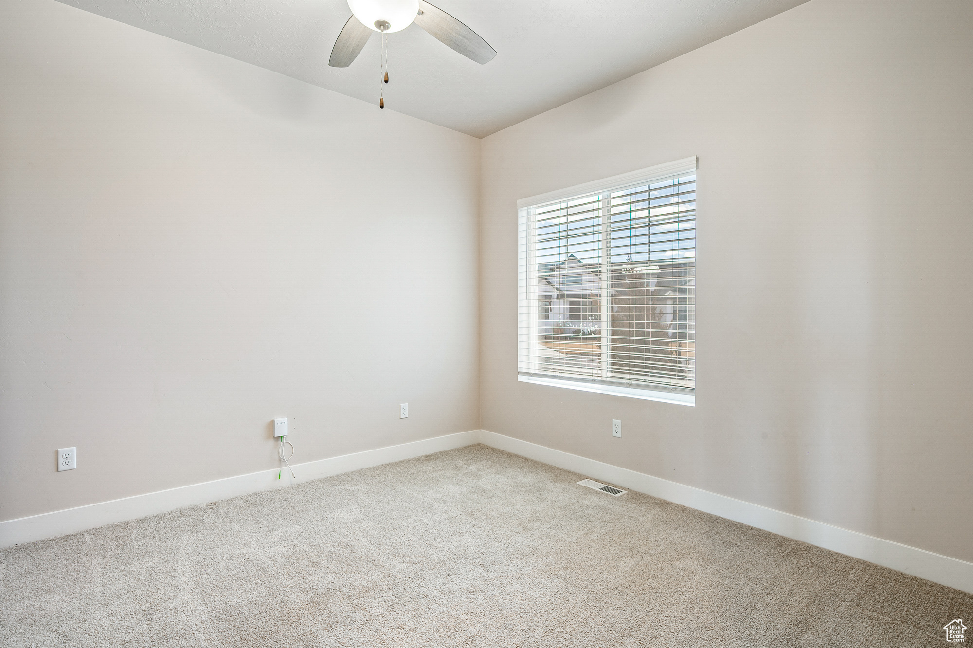 Empty room featuring ceiling fan and carpet flooring