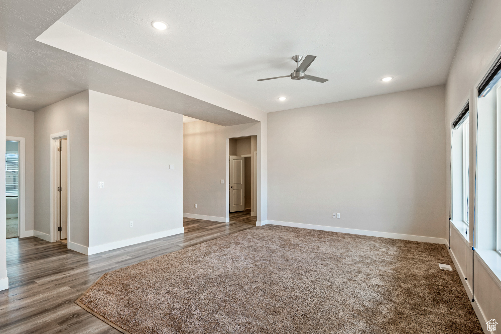 Empty room featuring dark hardwood / wood-style flooring and ceiling fan