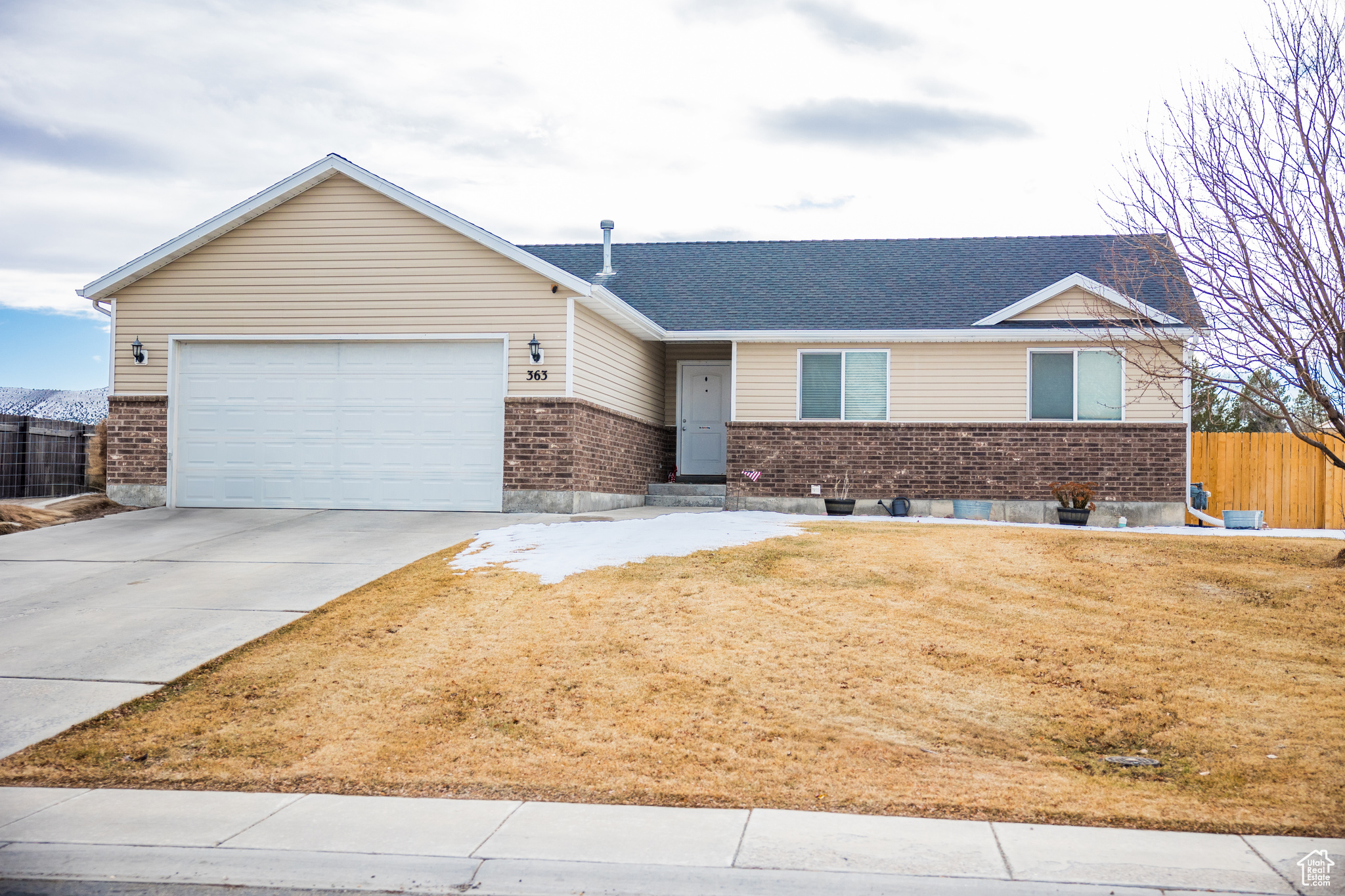 Single story home featuring a garage and a front yard