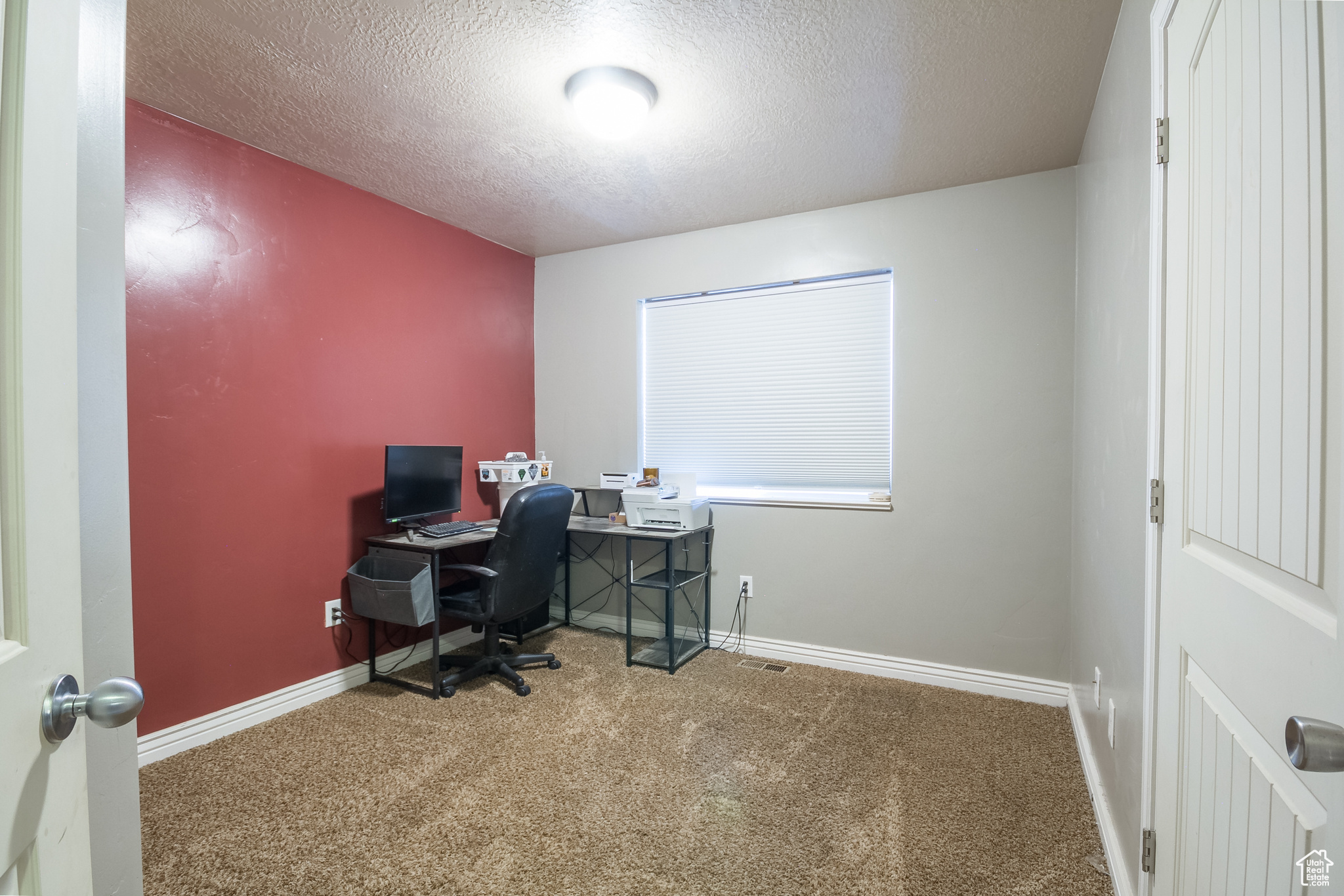 Office area with carpet and a textured ceiling
