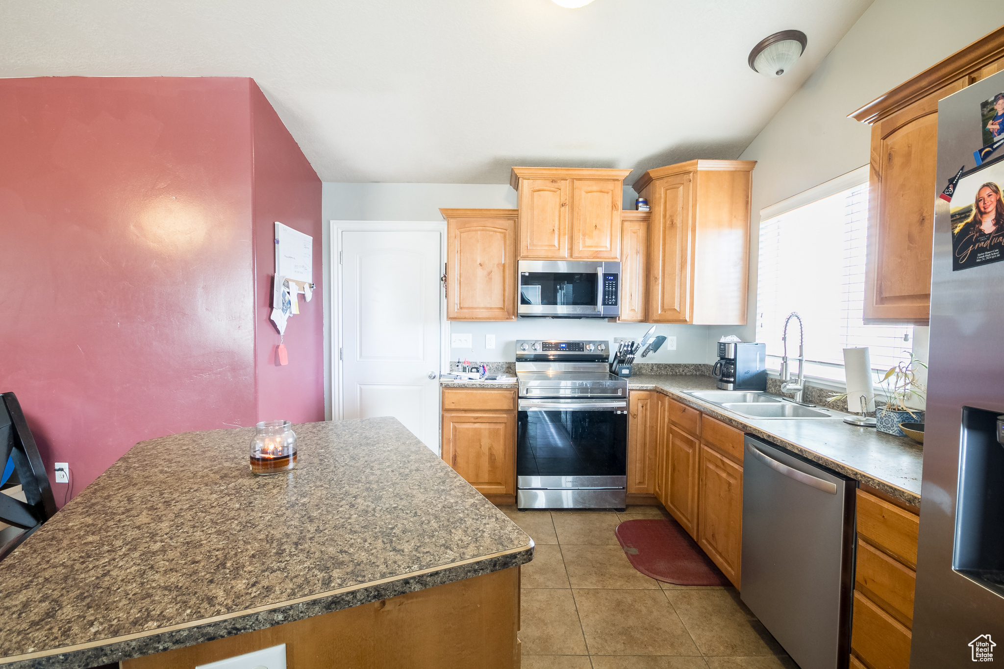 Kitchen featuring light tile patterned floors, stainless steel appliances, and sink