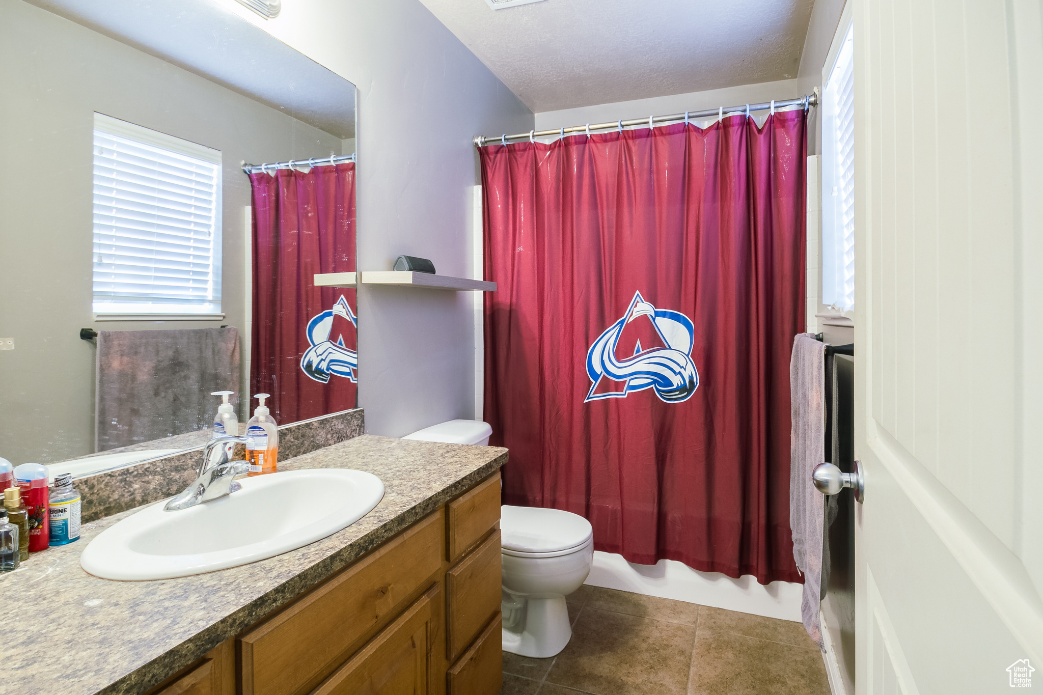 Bathroom featuring vanity, tile patterned flooring, and toilet