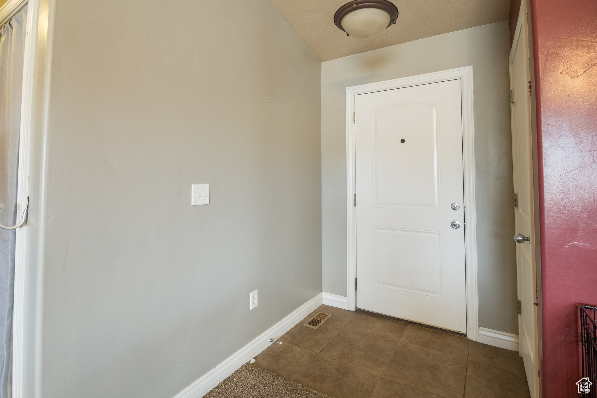 Doorway with dark tile patterned floors