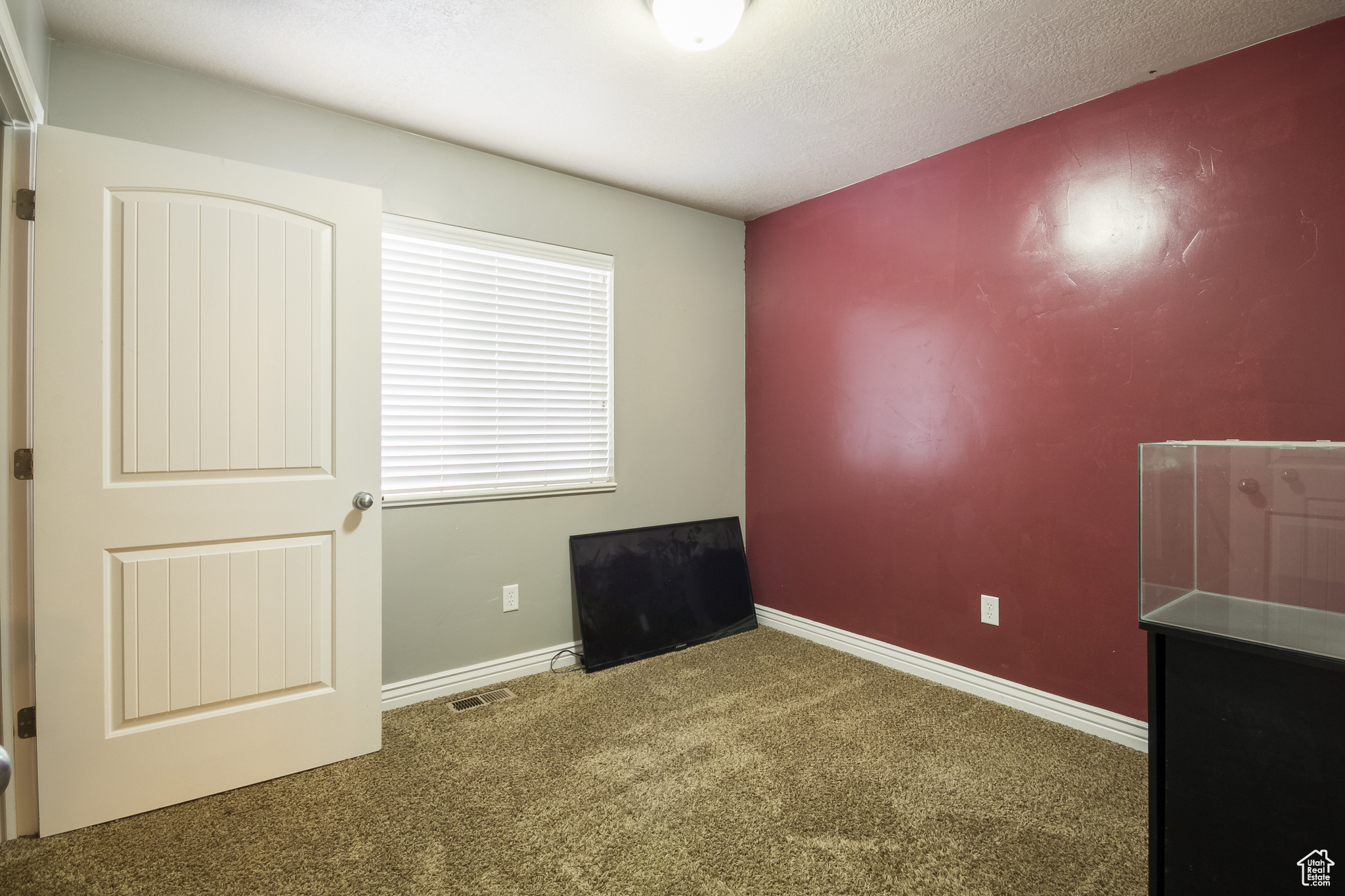Carpeted spare room featuring a textured ceiling