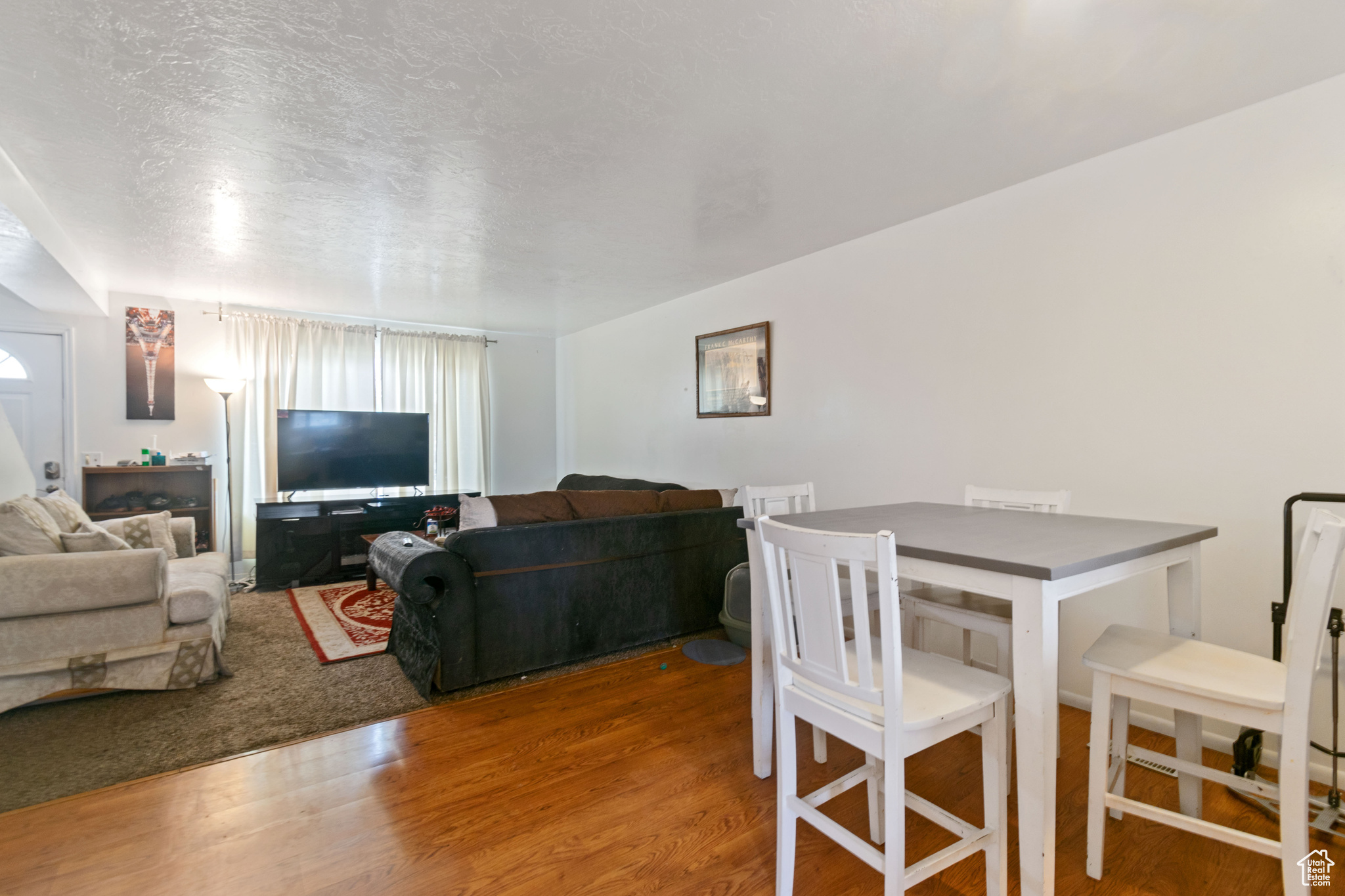 Living room with a textured ceiling and wood finished floors
