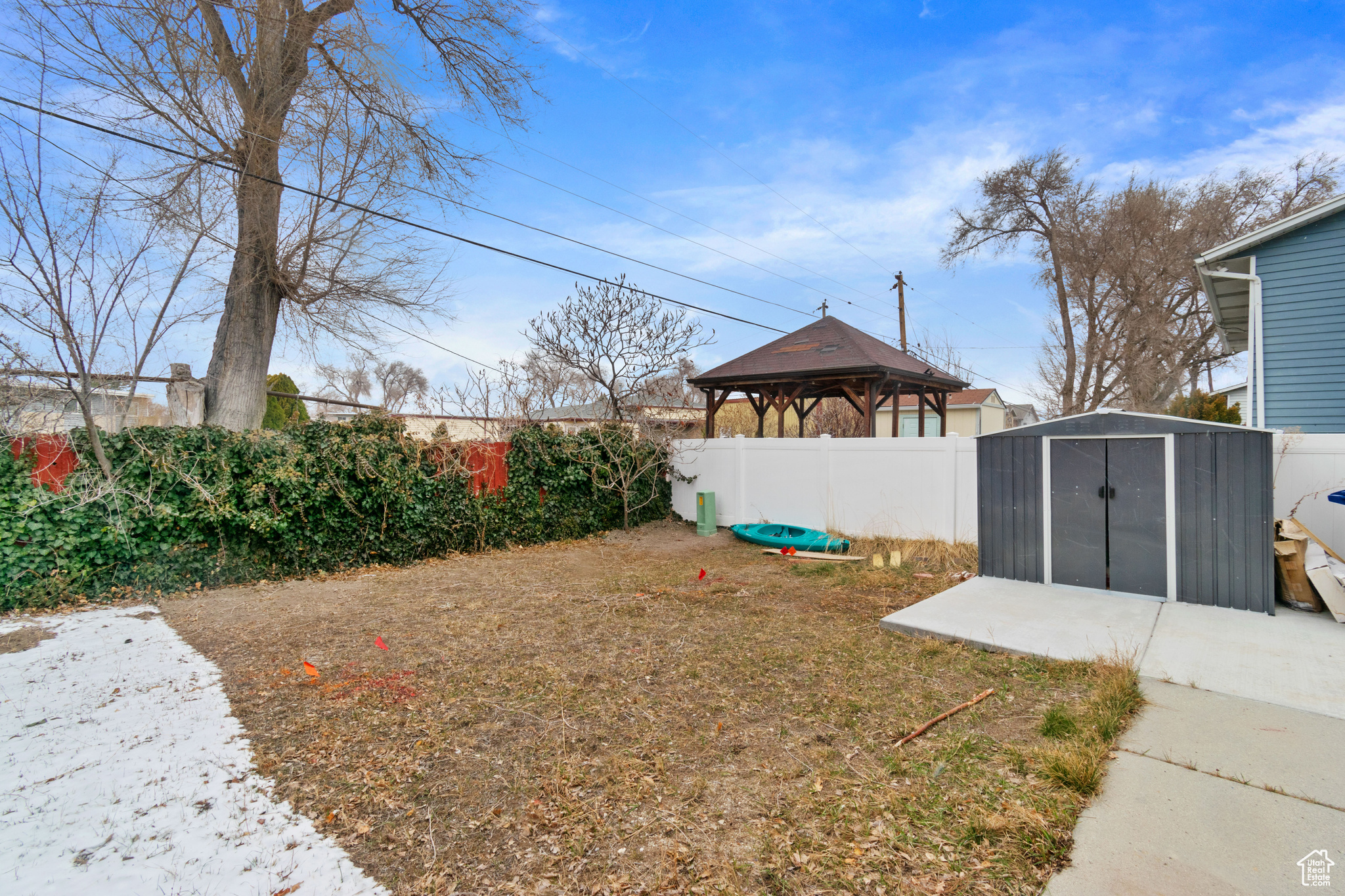 View of yard featuring a fenced backyard, an outbuilding, a storage unit, and a gazebo