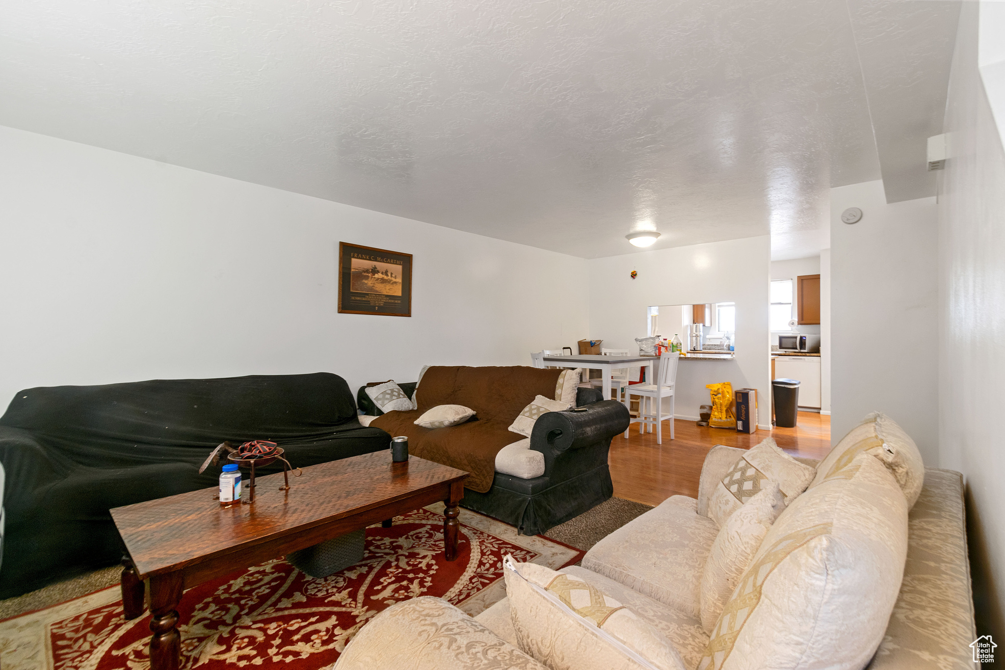 Living area featuring light wood finished floors and a textured ceiling