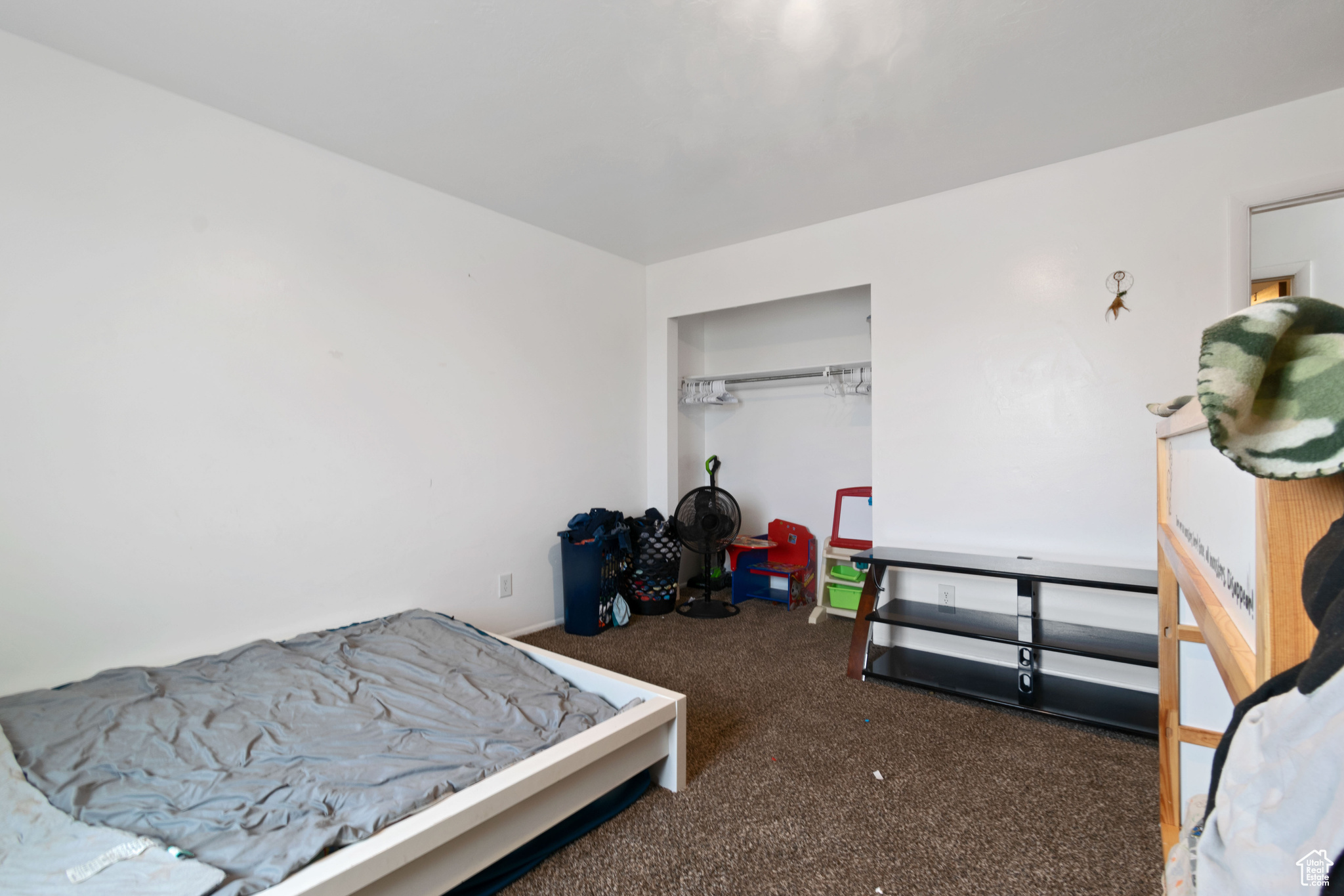 Bedroom featuring dark colored carpet and a closet