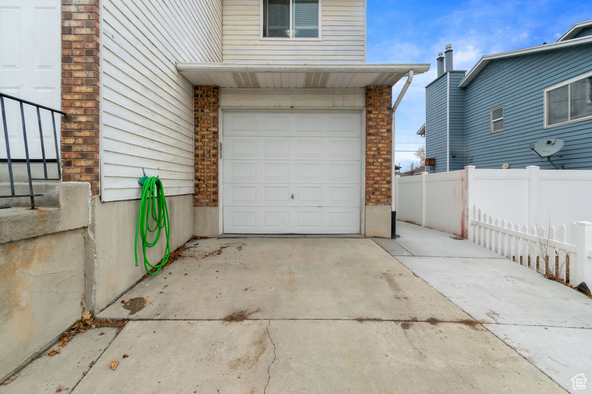 Garage with fence and concrete driveway