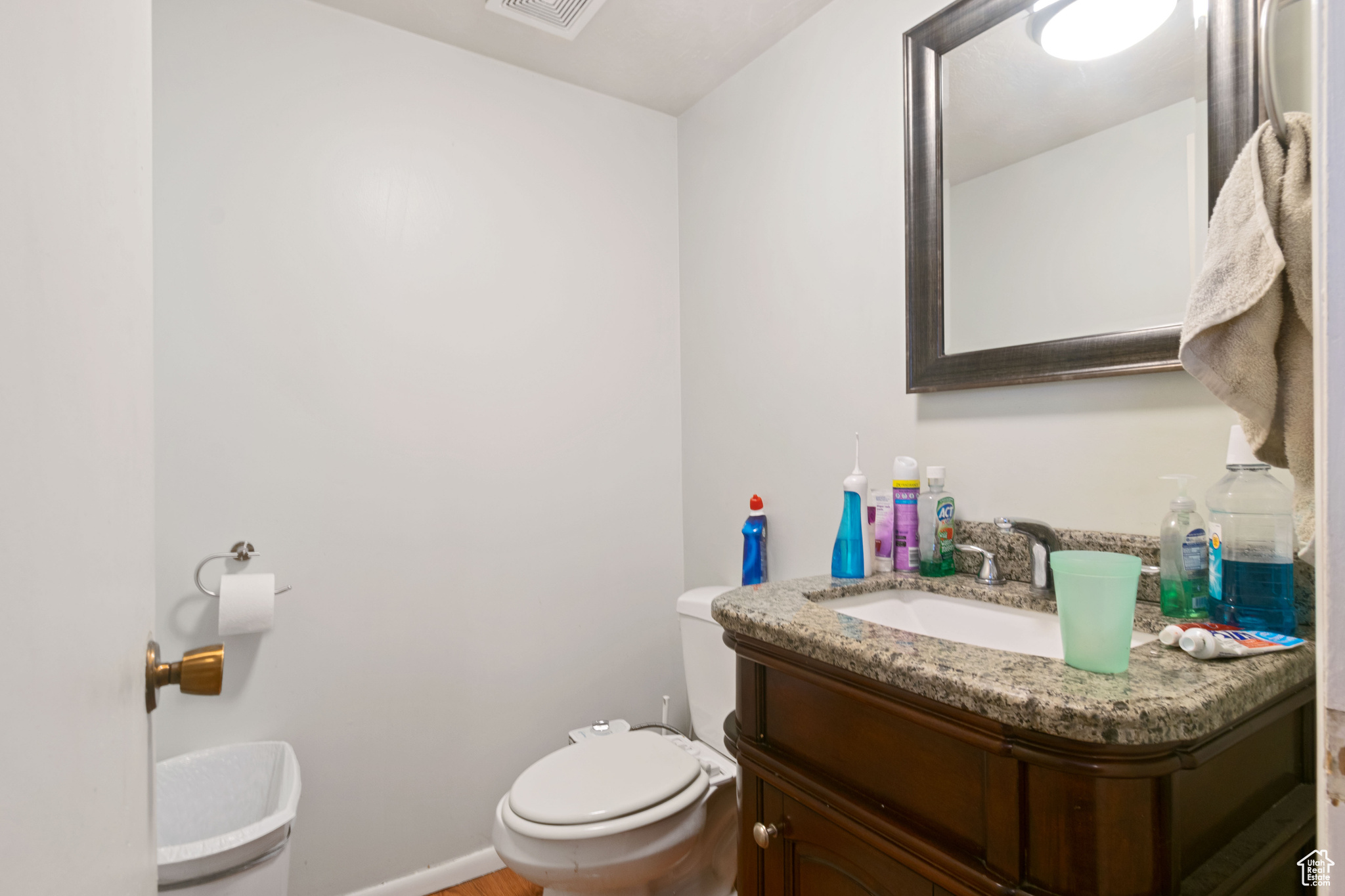 Bathroom with vanity, toilet, visible vents, and baseboards