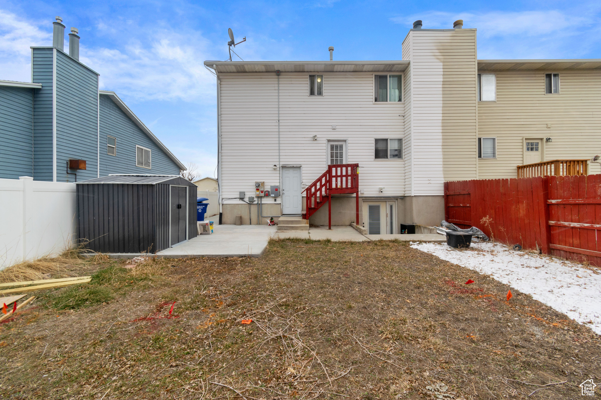 Rear view of house featuring a fenced backyard, an outbuilding, a storage unit, and a patio area