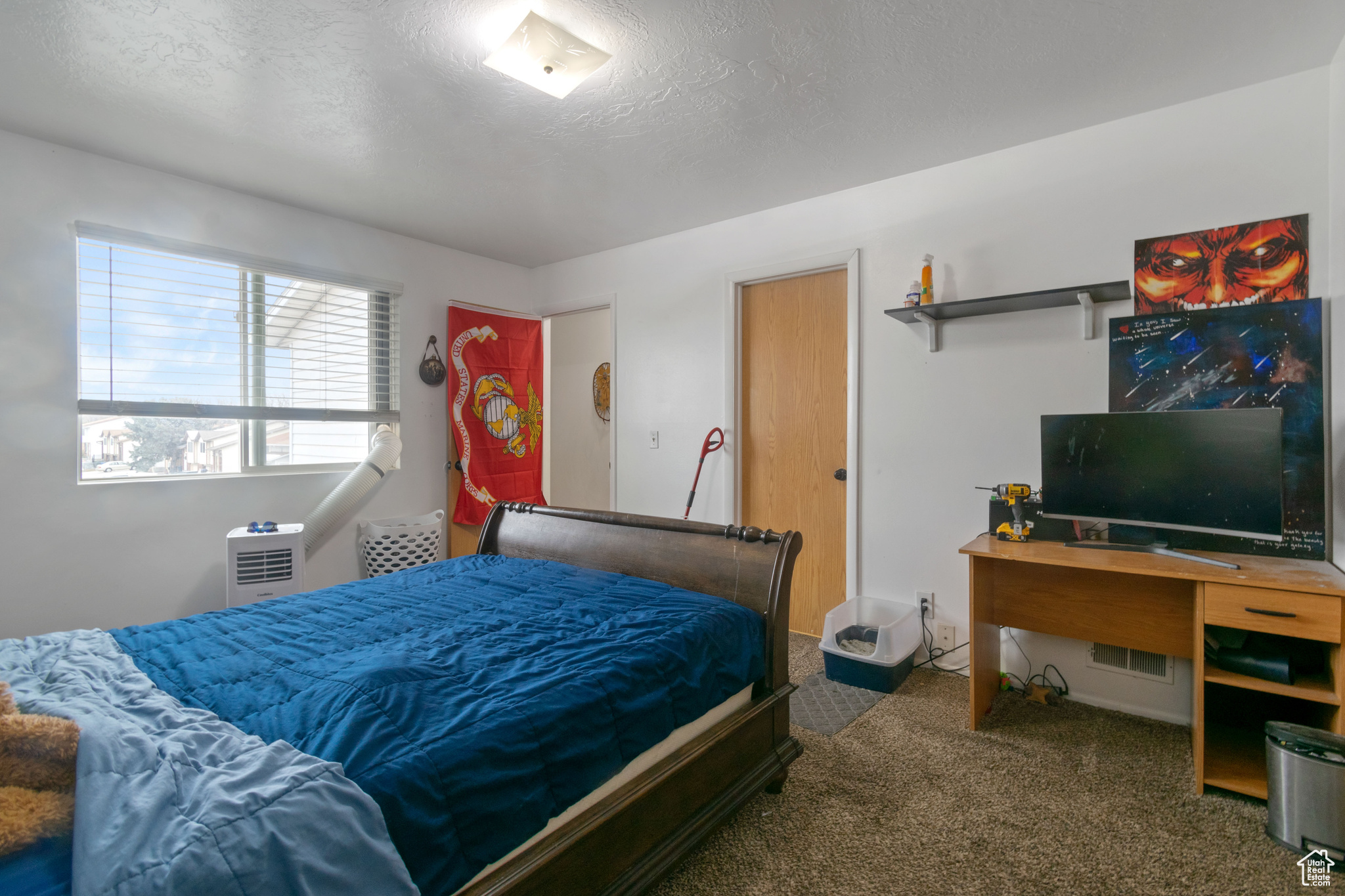 Bedroom with a textured ceiling and dark carpet