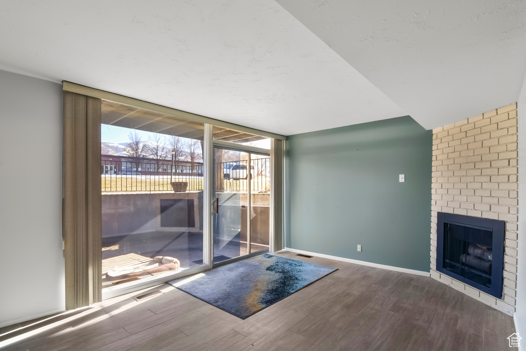 Entryway featuring floor to ceiling windows, a fireplace, baseboards, and wood finished floors