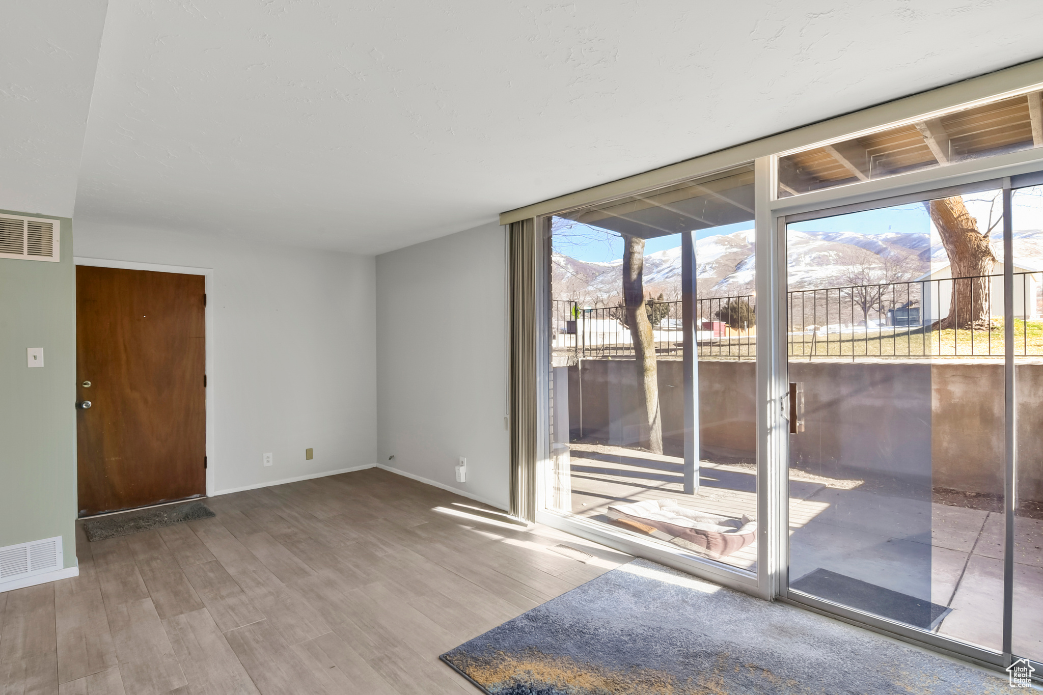 Spare room with visible vents, a mountain view, baseboards, and wood finished floors