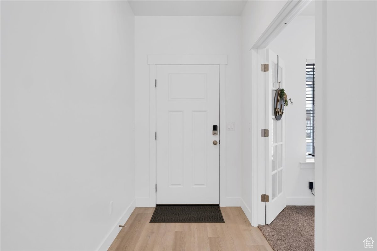 Entryway with baseboards and light wood-style floors