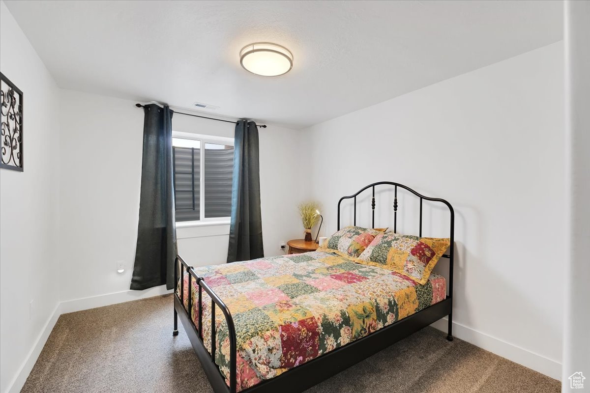 Bedroom featuring carpet, visible vents, and baseboards