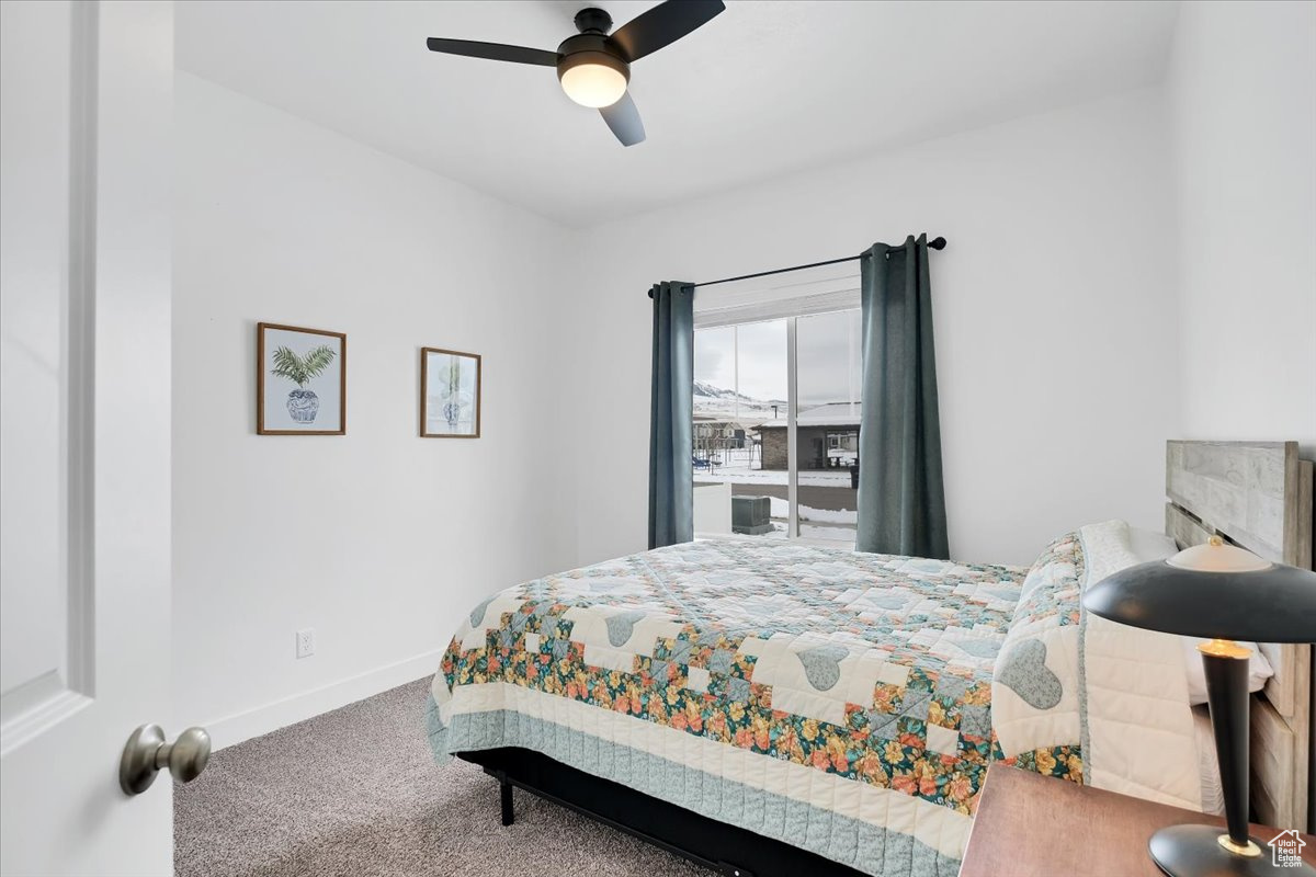Carpeted bedroom featuring a ceiling fan and baseboards