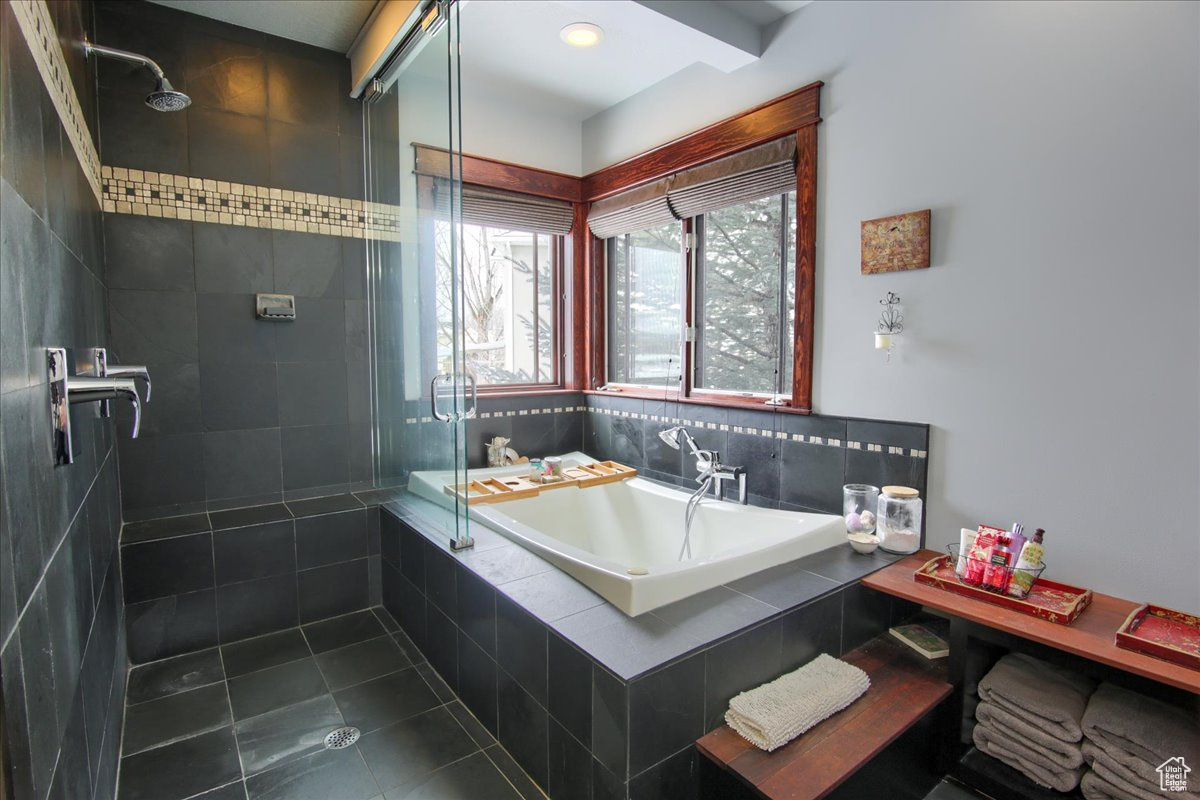 Bathroom with tile patterned flooring, a tile shower, and a bath