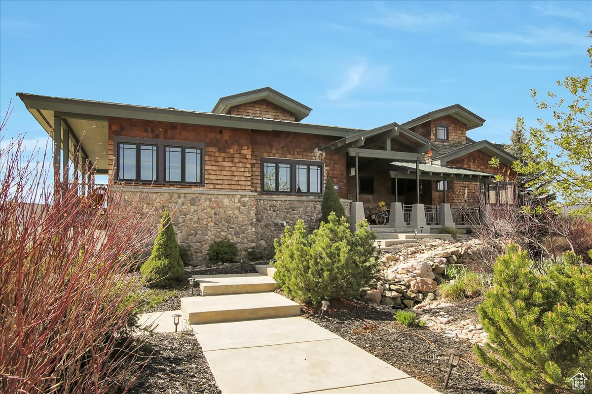 Chalet / cabin featuring covered porch and stone siding