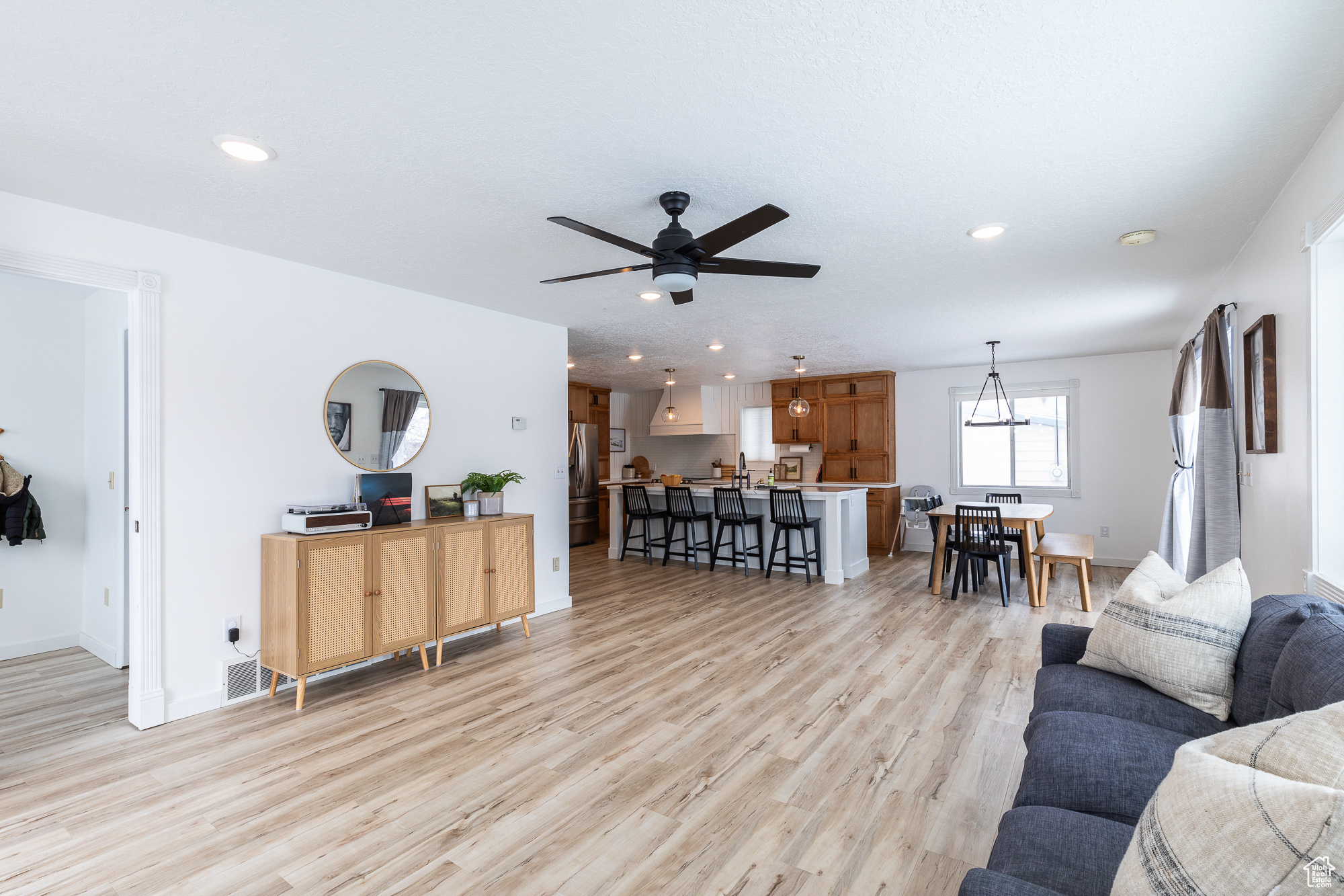 Living area with recessed lighting, light wood-style flooring, and baseboards