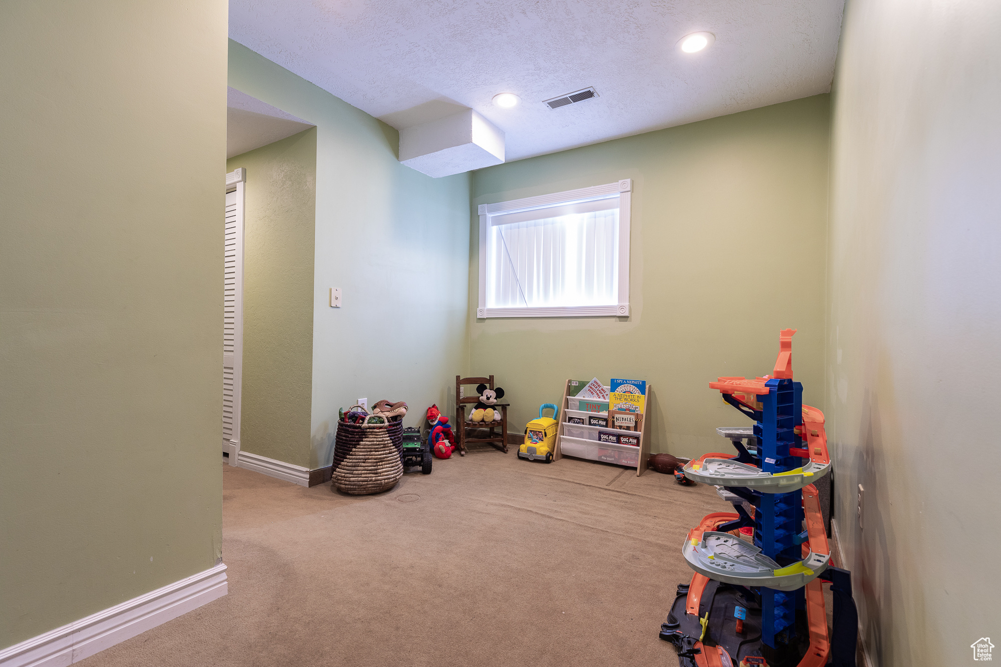 Playroom featuring a textured ceiling, recessed lighting, light carpet, visible vents, and baseboards