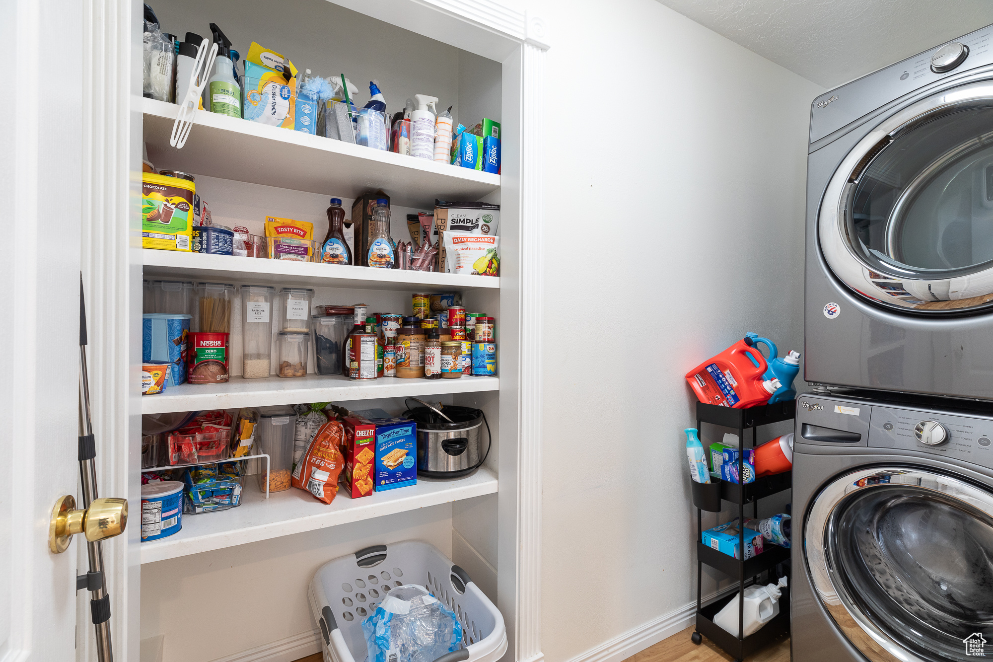 Laundry area with stacked washer and dryer, baseboards, and laundry area