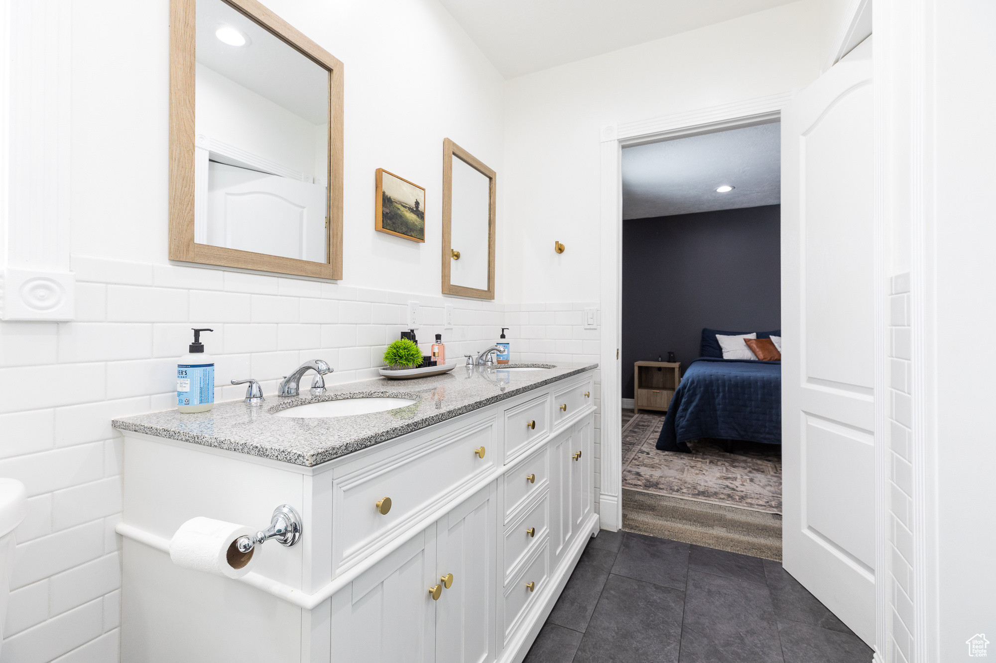 Ensuite bathroom featuring tile patterned floors, a sink, tile walls, and ensuite bathroom