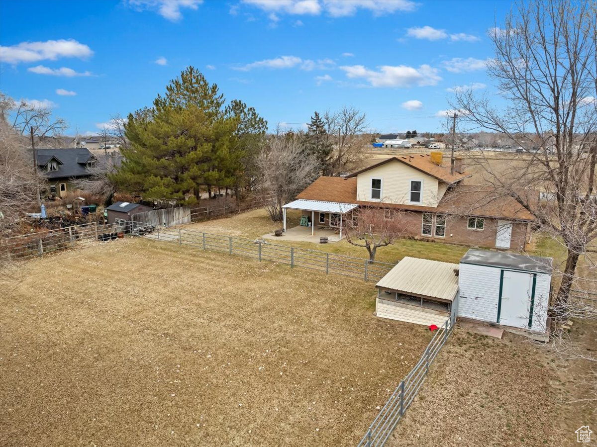 View of yard with a storage shed, an outdoor structure, and fence