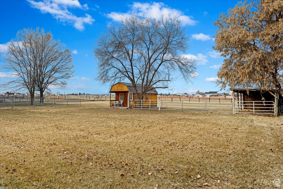 View of yard featuring an exterior structure, an outbuilding, and a rural view