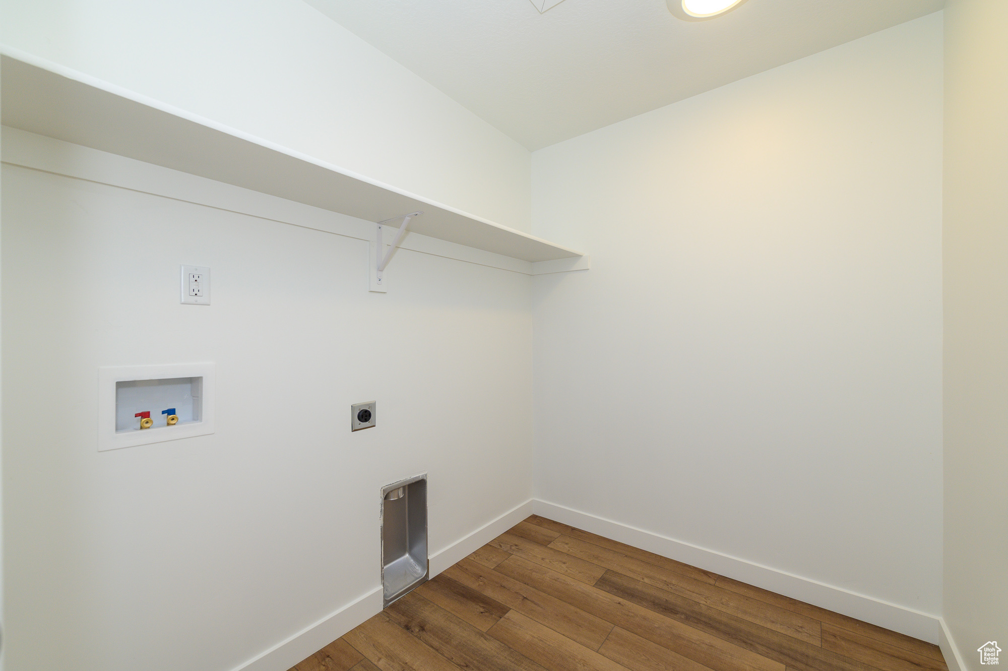 Laundry room with laundry area, baseboards, wood finished floors, washer hookup, and electric dryer hookup