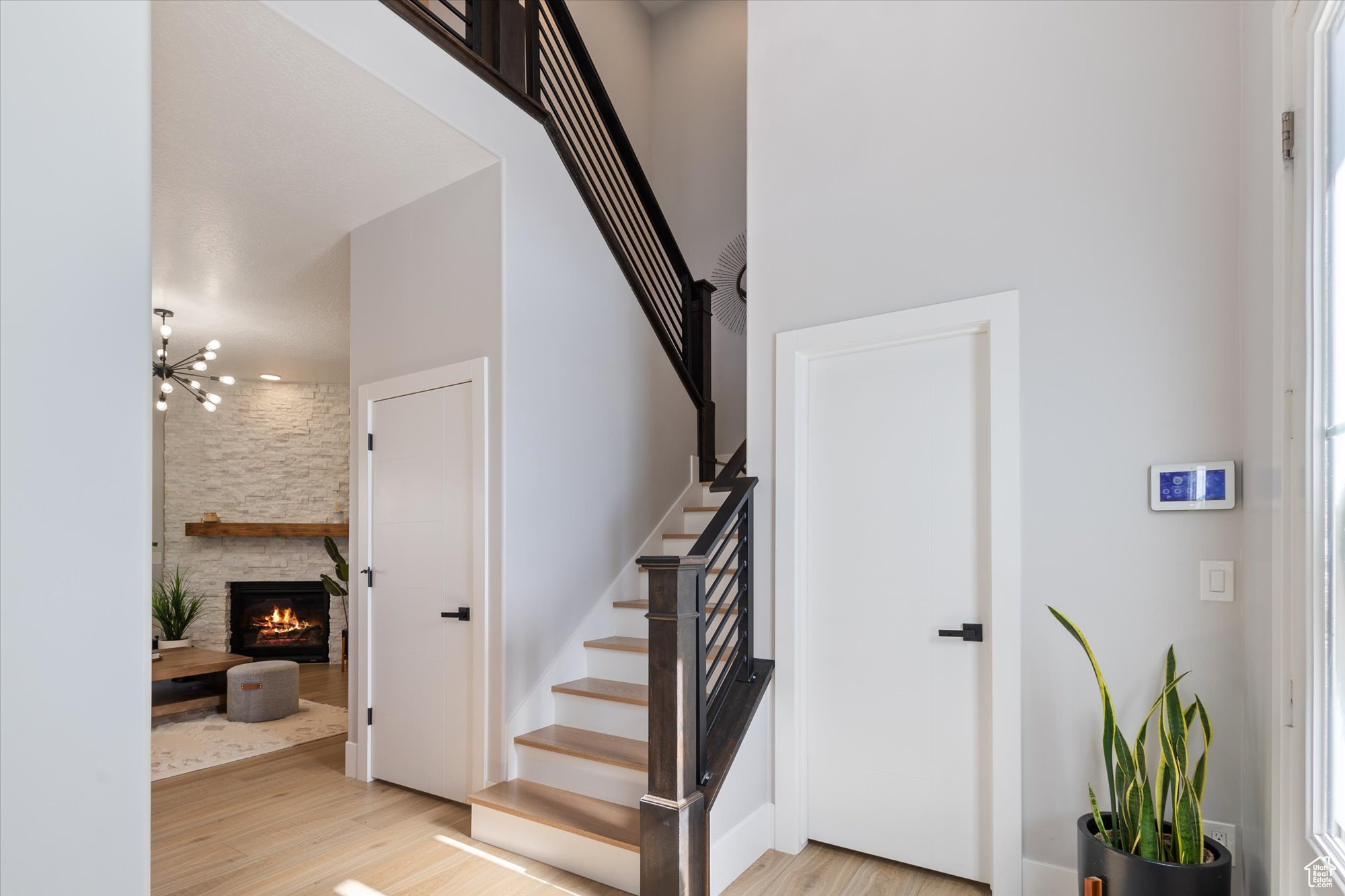 Stairs featuring hardwood / wood-style flooring and a stone fireplace