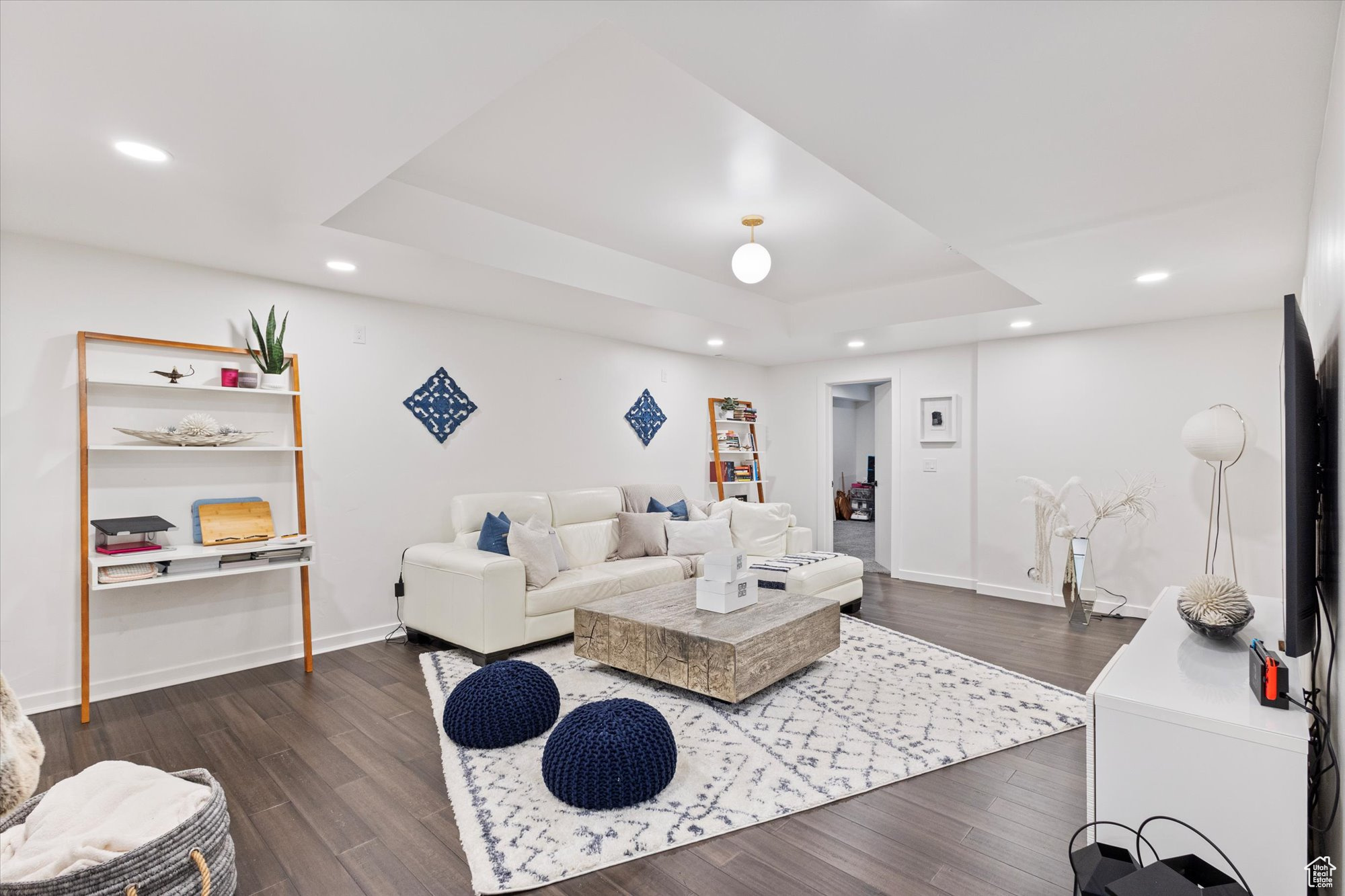 Living room with dark wood-type flooring and a raised ceiling