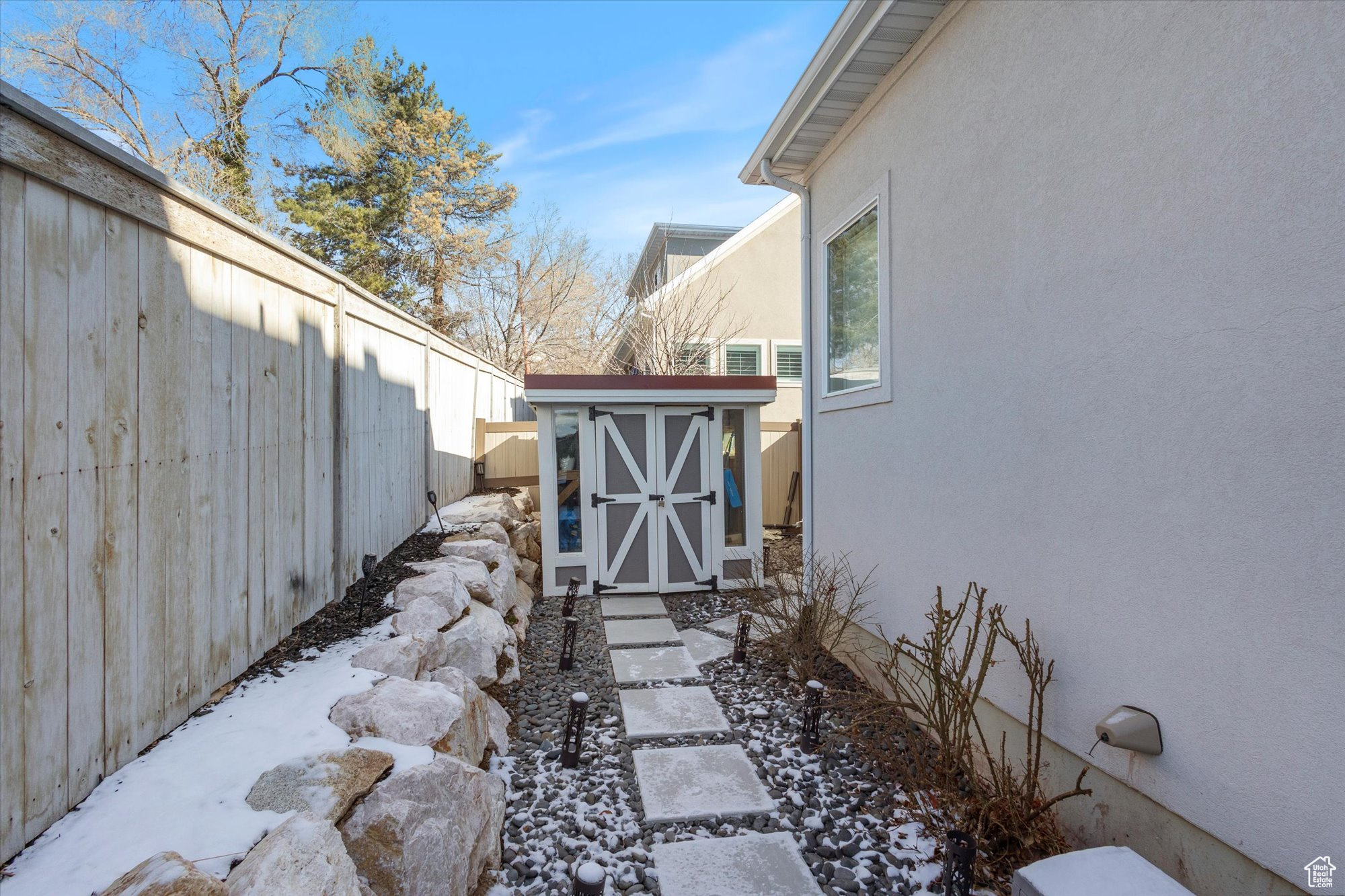 Yard layered in snow with a storage shed