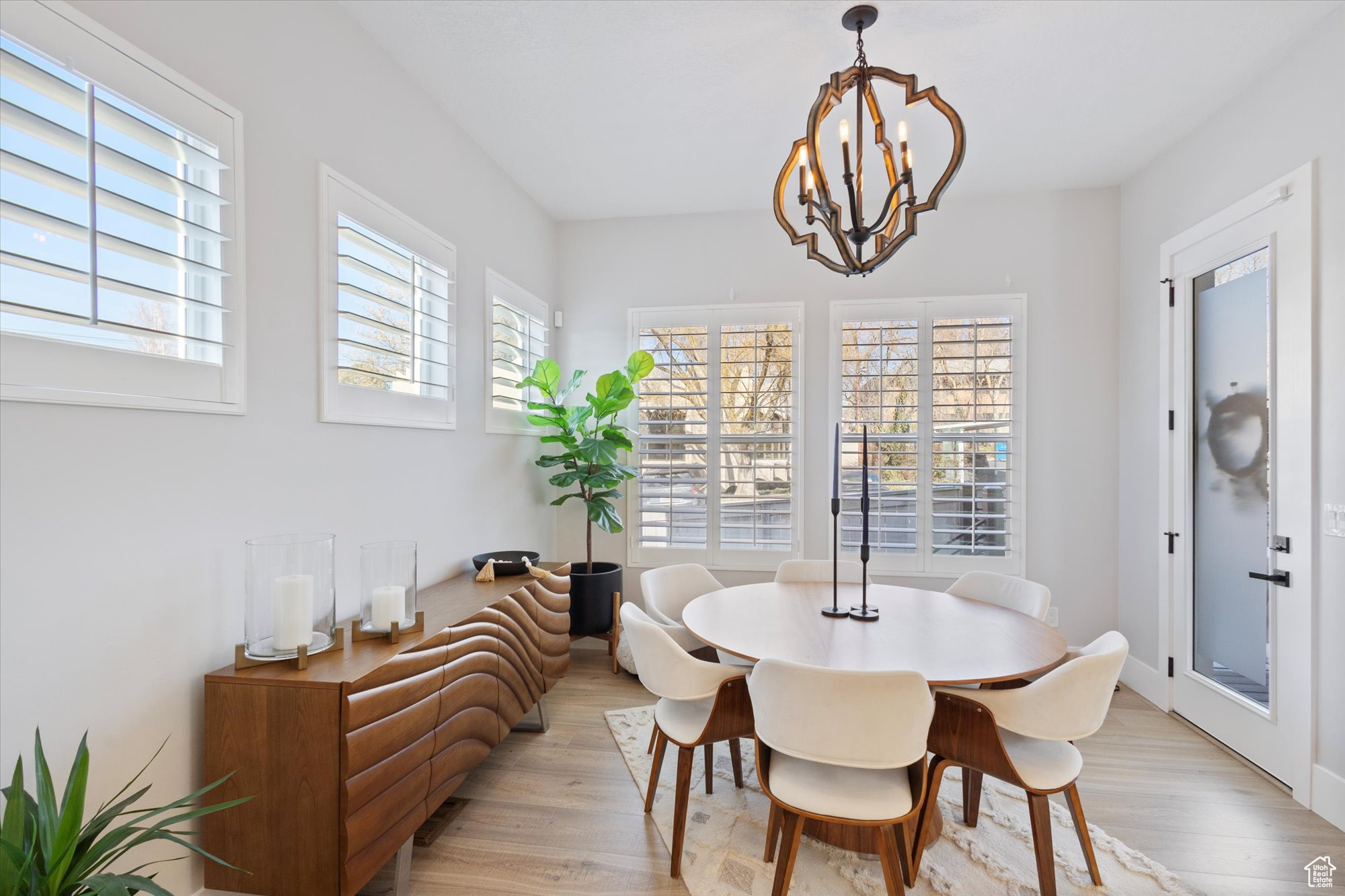 Dining area with plenty of natural light, light hardwood / wood-style floors, and a chandelier