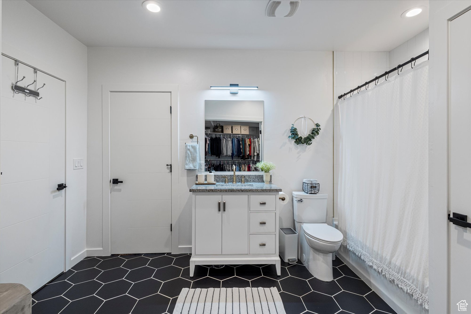 Bathroom with vanity, toilet, and curtained shower