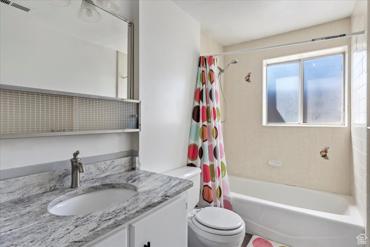 Full bath with shower / tub combo, visible vents, vanity, and toilet