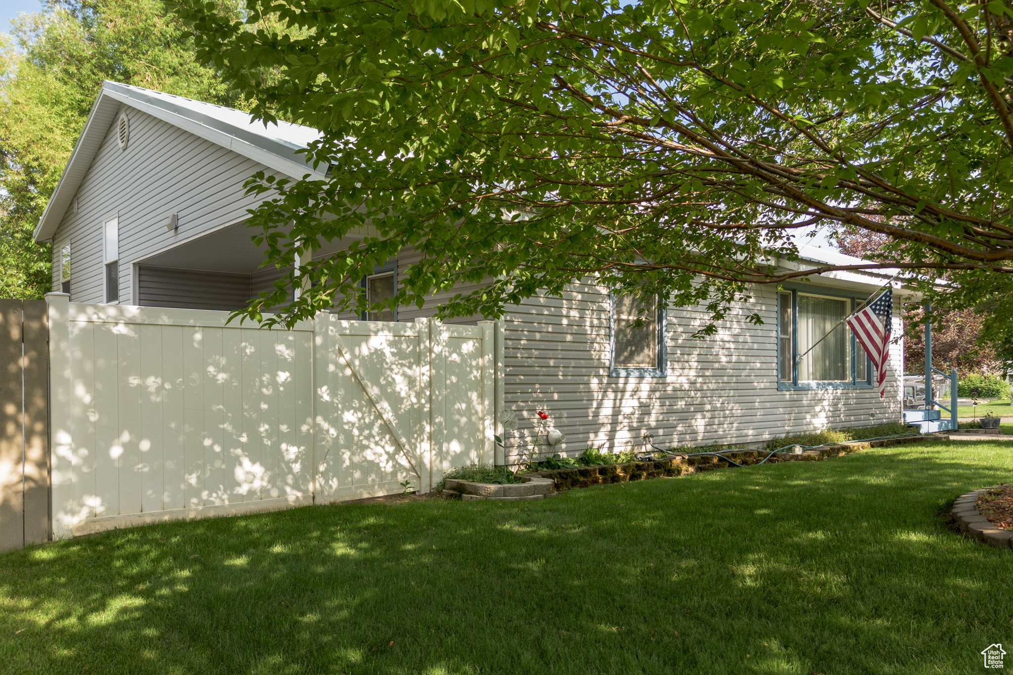 View of side of home featuring a lawn and fence