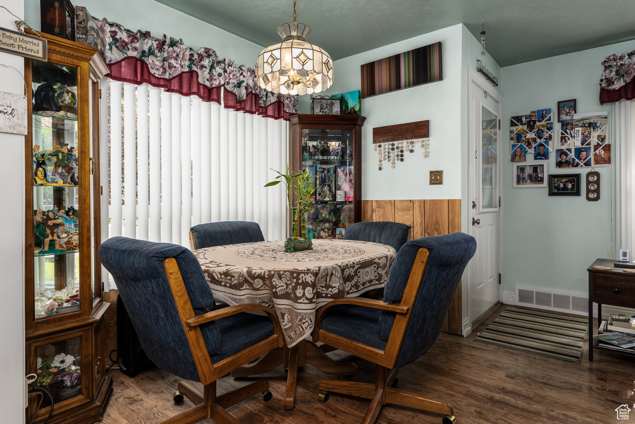 Dining space featuring wainscoting, dark wood finished floors, visible vents, and an inviting chandelier