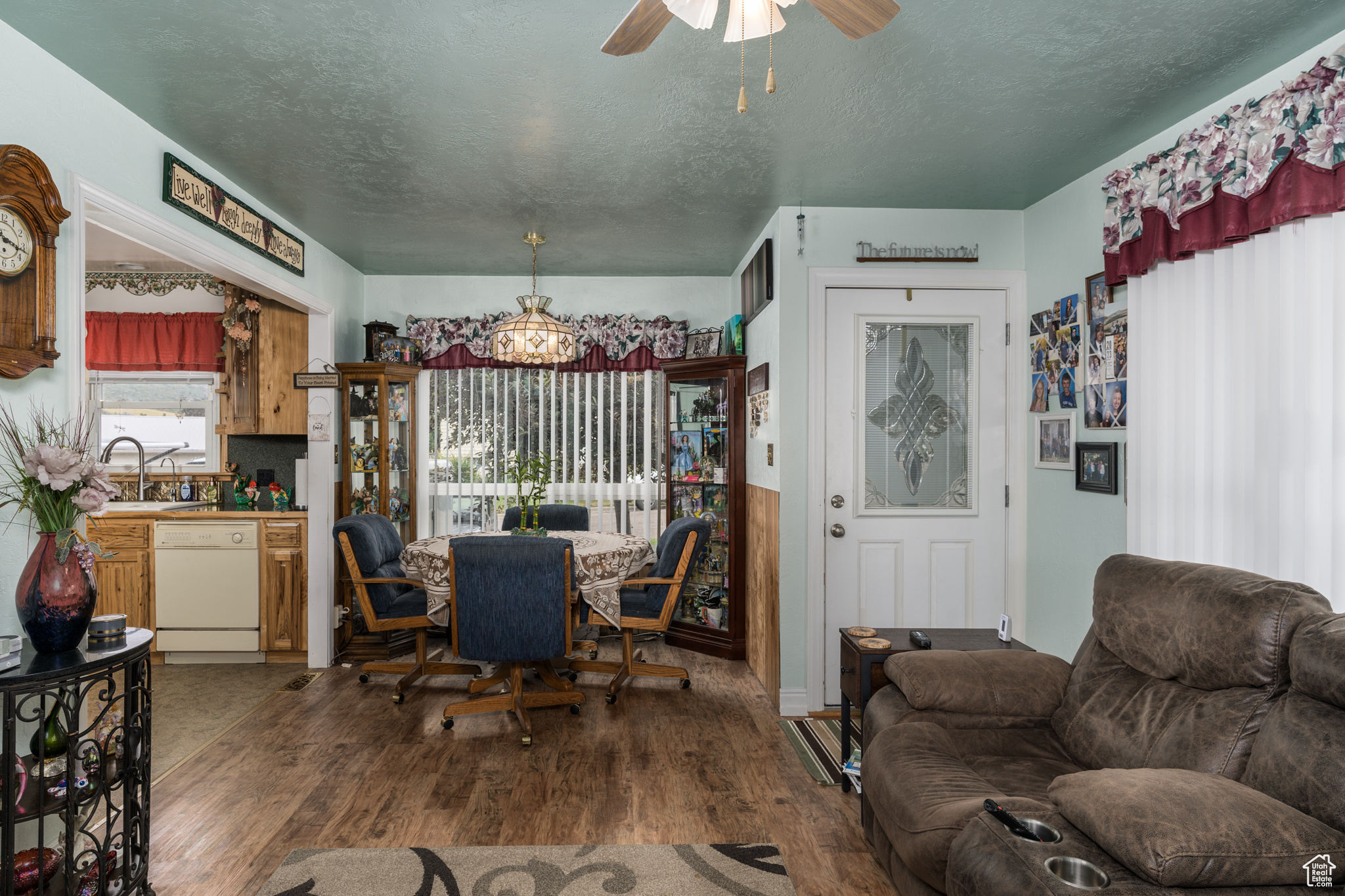Dining area featuring dark wood-style floors, a textured ceiling, and ceiling fan with notable chandelier