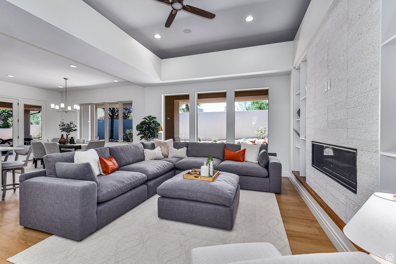 Living room featuring a tile fireplace, light hardwood / wood-style floors, plenty of natural light, and built in features