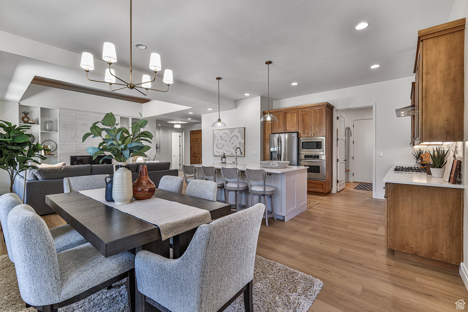 Dining space featuring light hardwood / wood-style flooring, a large fireplace, and a chandelier
