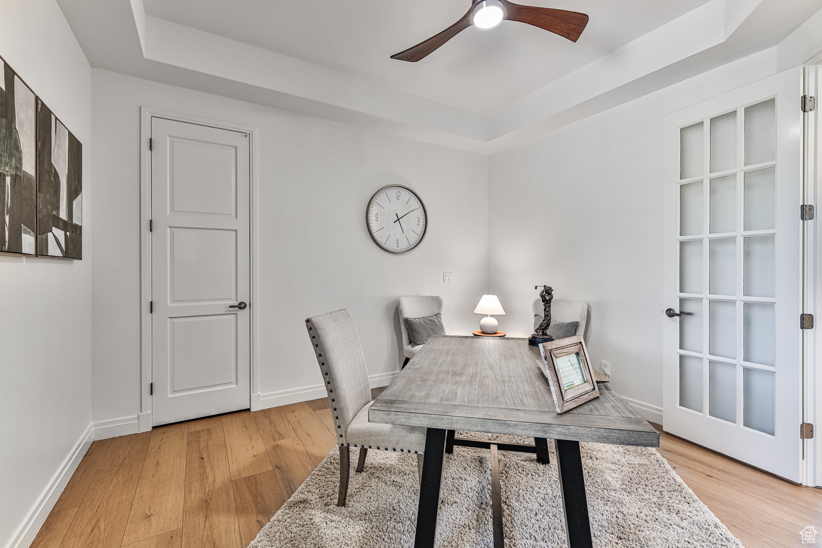 Office featuring a tray ceiling, ceiling fan, and light hardwood / wood-style floors