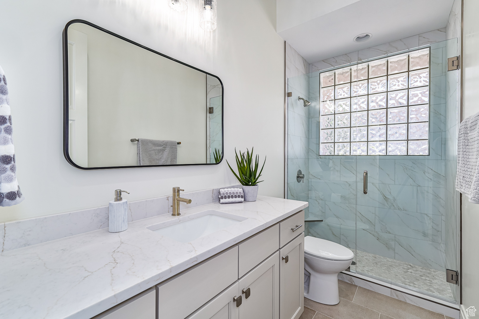 Bathroom with vanity, tile patterned flooring, toilet, and walk in shower