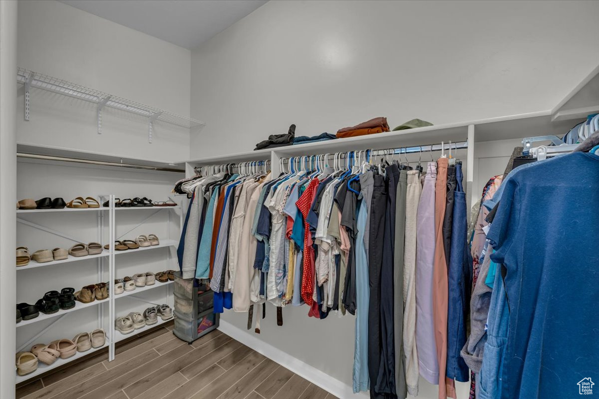 Walk in closet with wood finish floors