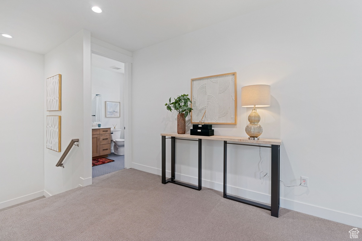 Corridor featuring light carpet, baseboards, an upstairs landing, and recessed lighting