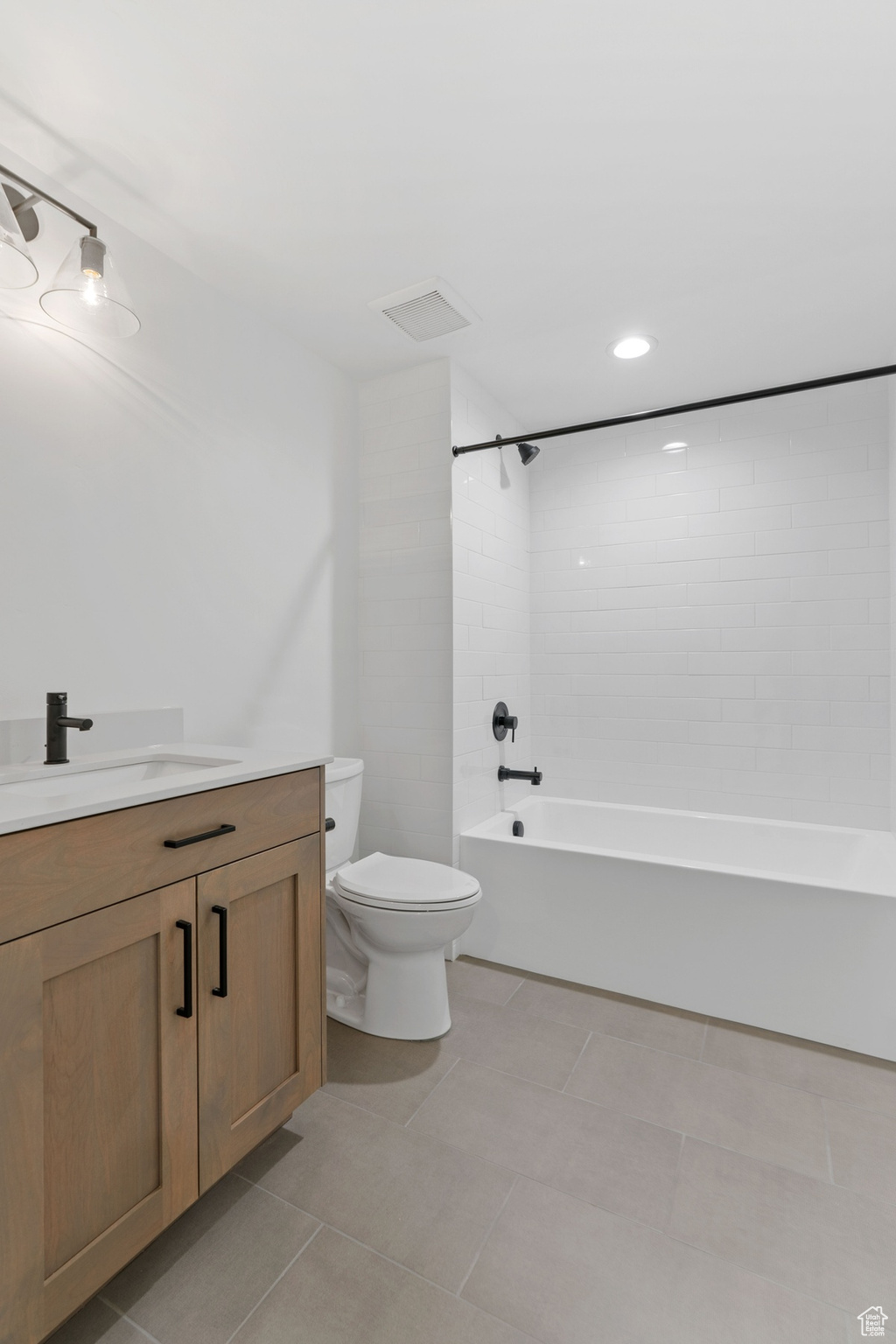 Bathroom with visible vents, toilet, tub / shower combination, vanity, and tile patterned flooring