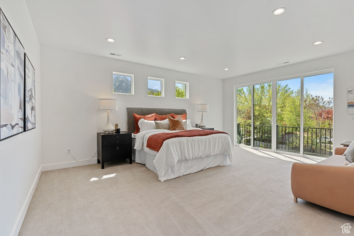 Bedroom with visible vents, baseboards, light colored carpet, access to outside, and recessed lighting